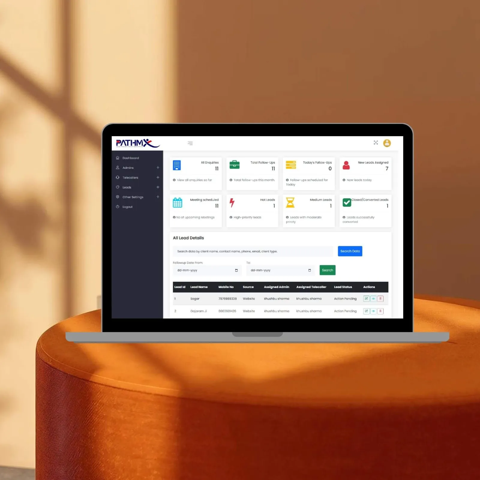 Multi-user lead software by CoregenX with telecaller lead assignments, shown on a laptop